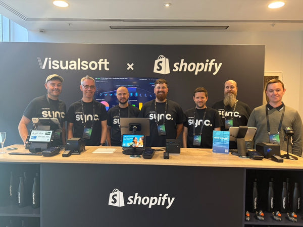 The team behind the Innovation Room at sync 2026, standing at the Visualsoft and Shopify retail counter.