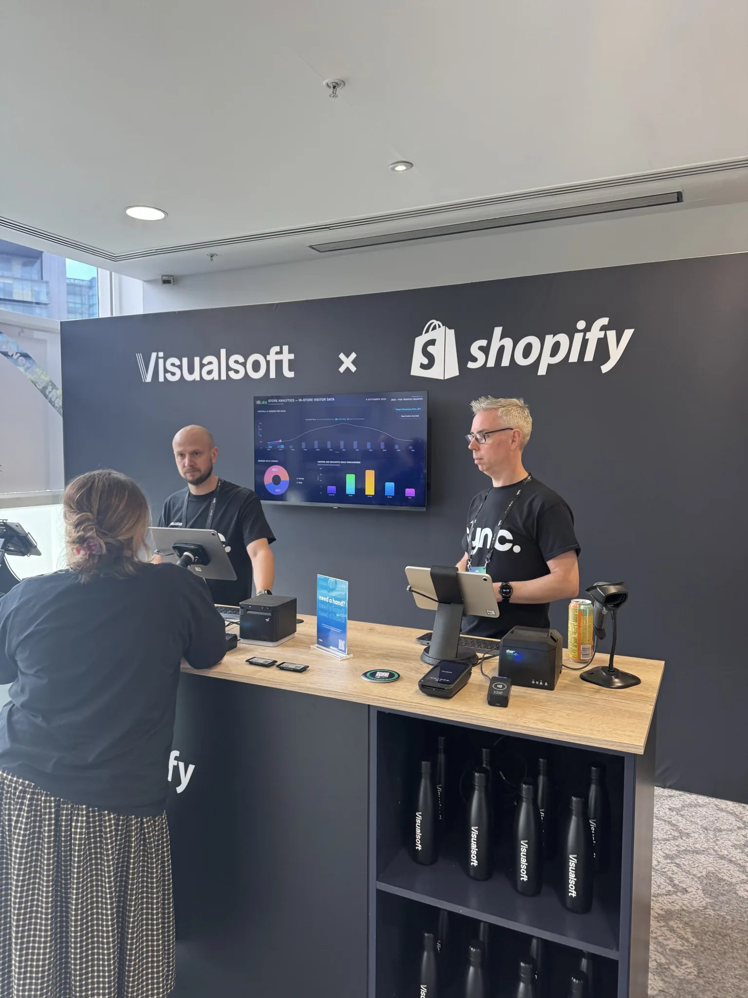Staff demonstrating the Shopify retail counter to a visitor at the event